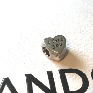 Elevate your bracelet with the Pandora Genuine 925 Sterling Silver I Love You Heart Charm, an emblem of affection and a timeless addition to your jewellery collection. The charm boasts an exquisite heart shape with the Wording… I Love you … engraved on both sides.